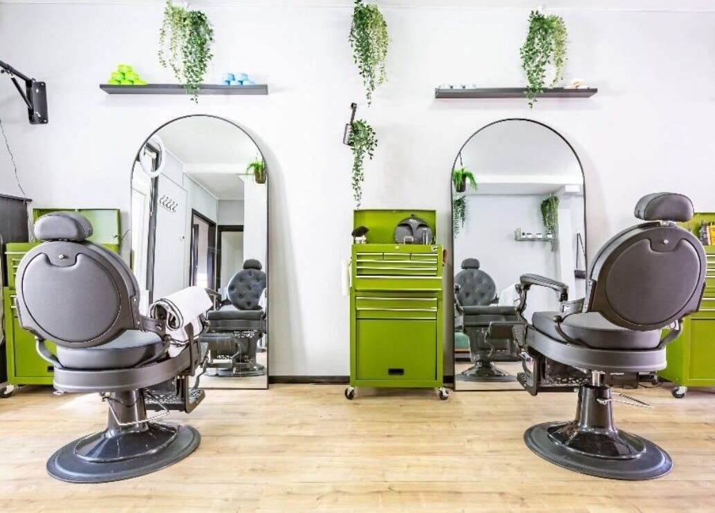 Modern salon interior at Mourid Zuid, Amsterdam, Noord-Holland, NL with green accents and sleek chairs.