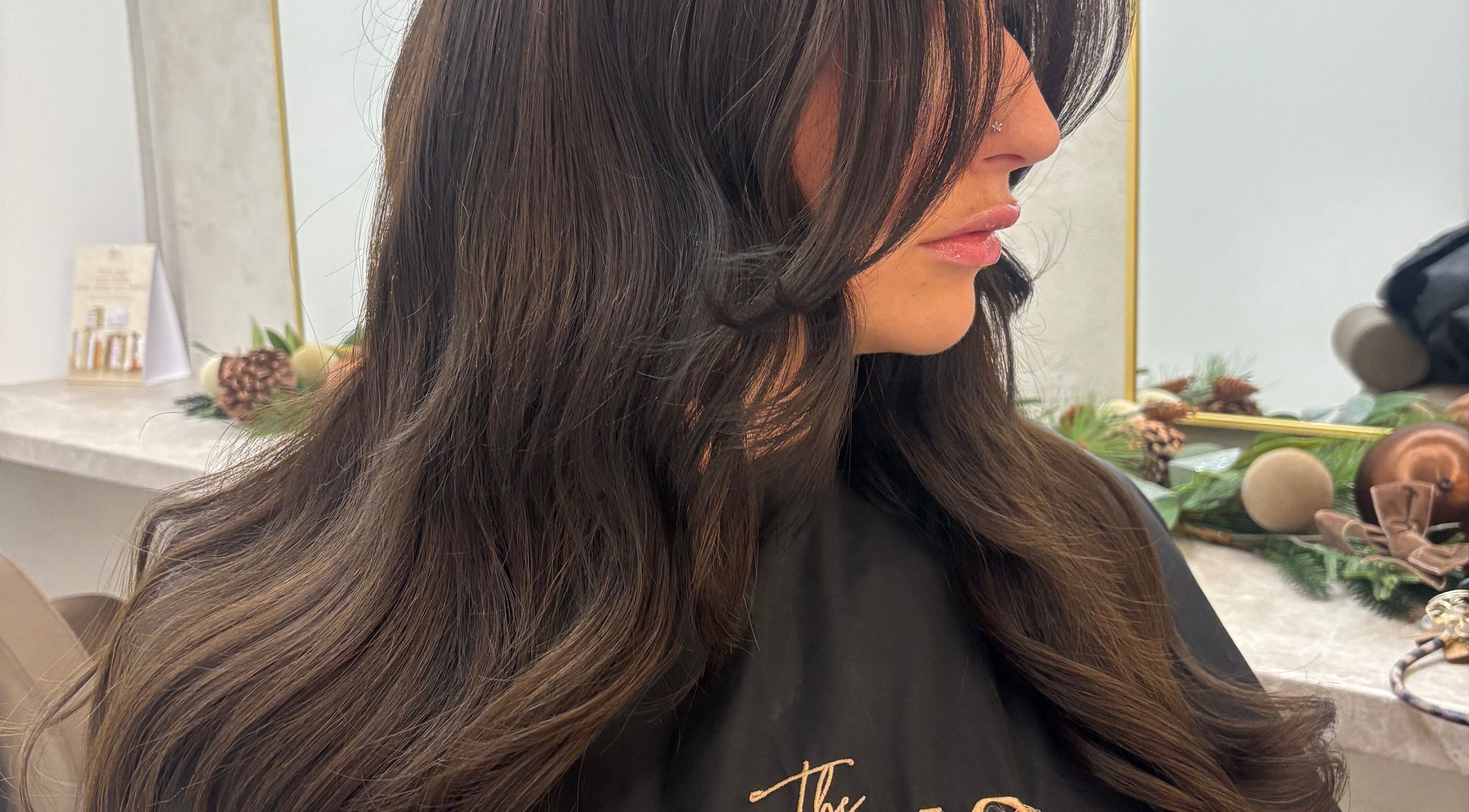 Woman with sleek dark hair styled in voluminous waves at Styled By Eve, Billingham, England, GB.