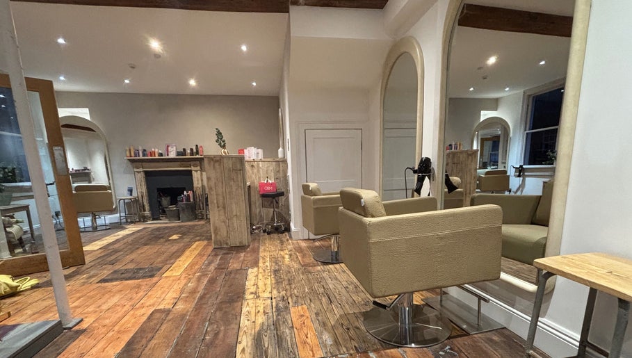 Elegant interior of Folly & Hue Hair And Beauty Studio in Bradford-on-Avon, England. Cozy chairs and rustic decor.
