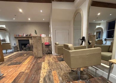 Elegant interior of Folly & Hue Hair And Beauty Studio in Bradford-on-Avon, England. Cozy chairs and rustic decor.