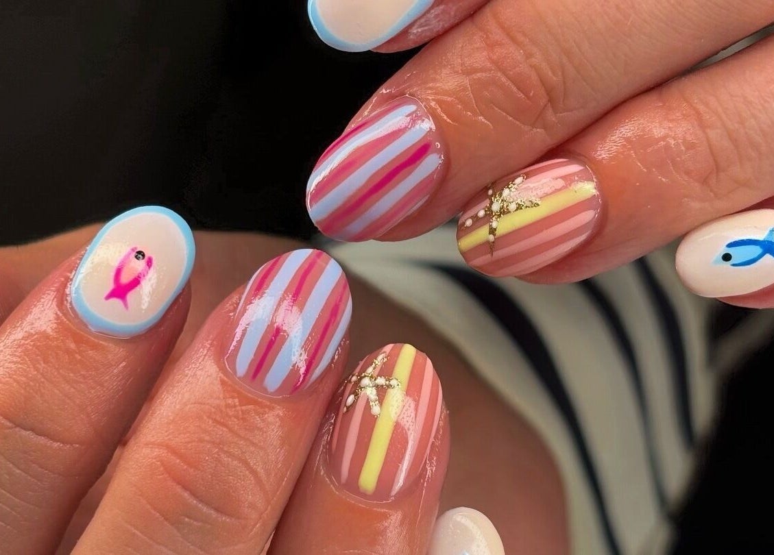 Stylish nail art with stripes and fish at Mani’s by Millie May, Bridgend, Wales, GB for a colorful look.
