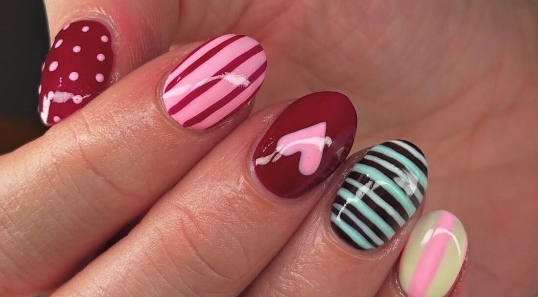 Colorful nail art at Mani’s by Millie May, Bridgend, Wales, GB, showcasing stripes and dots.