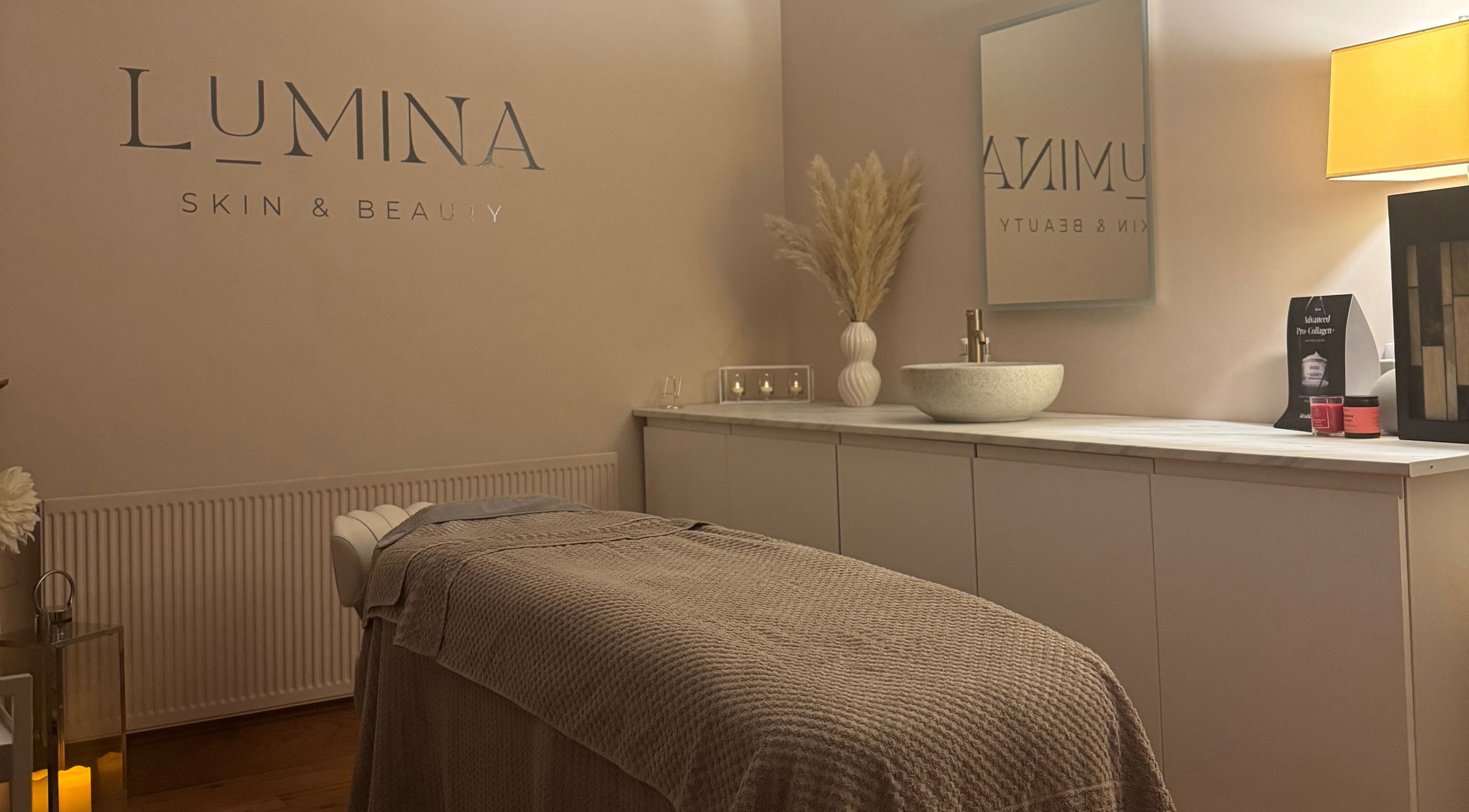 Relaxing spa room at Lumina Skin & Beauty, Barnoldby Le Beck, England, featuring a massage table and ambient lighting.