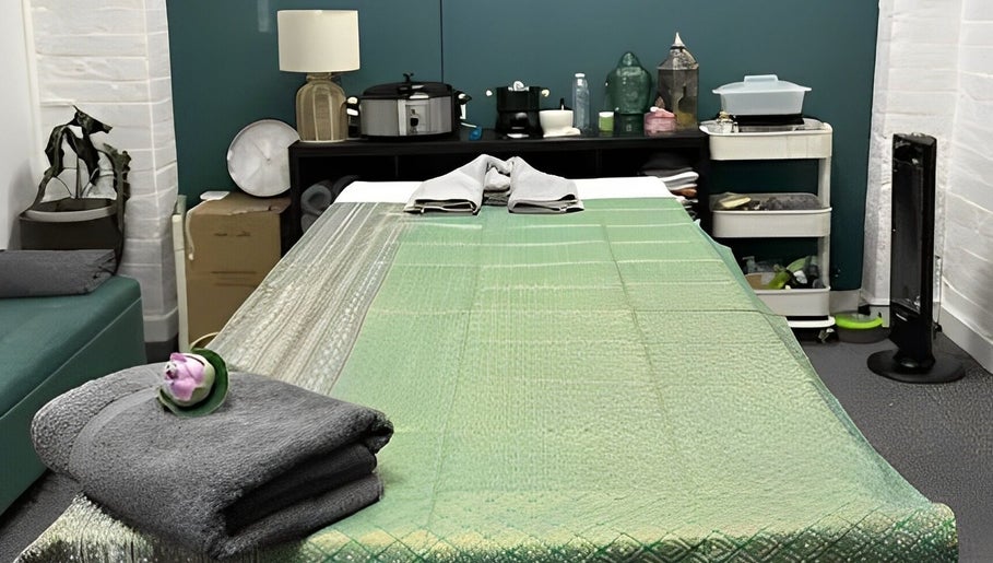 Afon Thai Massage treatment room with green sheets in Cardiff, Wales, GB.