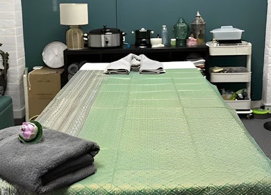 Afon Thai Massage treatment room with green sheets in Cardiff, Wales, GB.