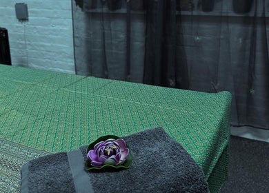 Peaceful massage table at Afon Thai Massage, Cardiff, Wales, GB with a towel and flower.