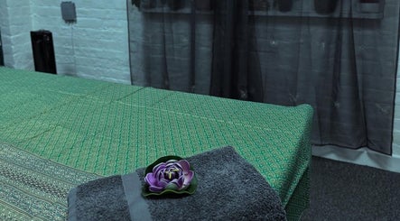 Peaceful massage table at Afon Thai Massage, Cardiff, Wales, GB with a towel and flower.