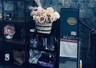 Cozy interior of Afon Thai Massage in Cardiff, Wales, GB with elegant floral arrangements and stylish shelving.
