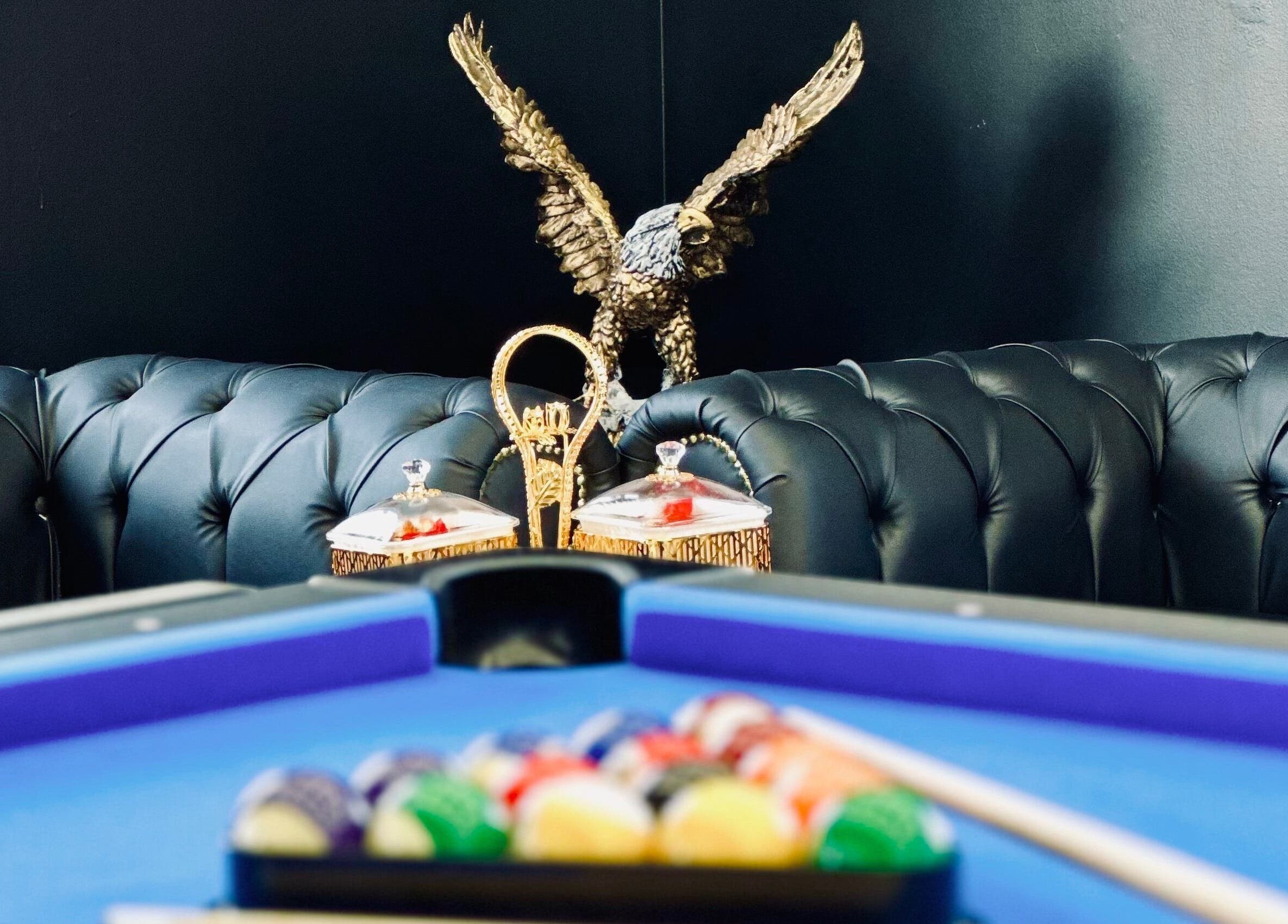 Luxurious lounge at Royaltrim, Stavanger, Rogaland, with a pool table and eagle sculpture.