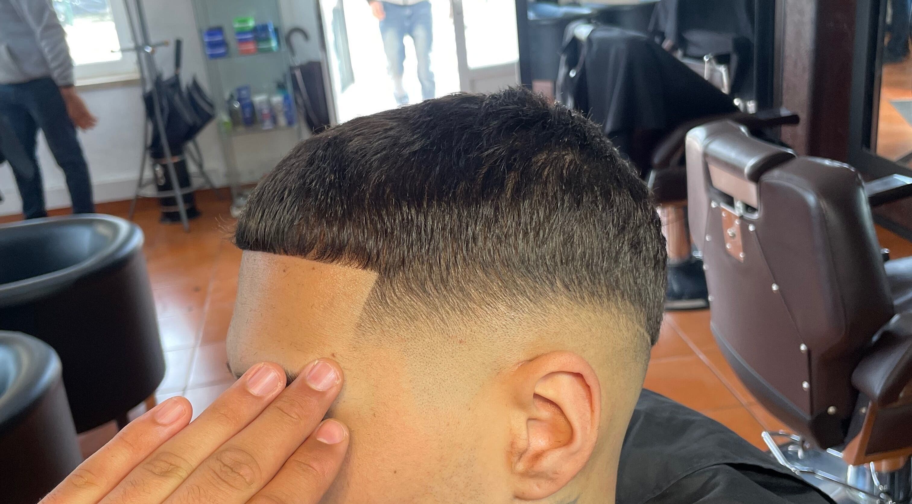 Barbeiro finalizando corte masculino no PASSARO BARBER, Alcabideche, Lisboa, PT.