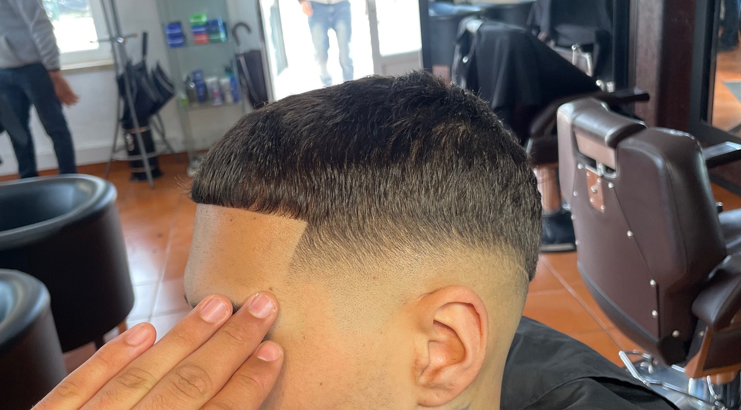 Barbeiro finalizando corte masculino no PASSARO BARBER, Alcabideche, Lisboa, PT.