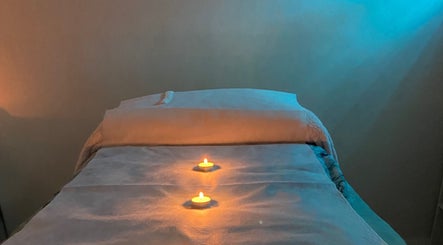 Relaxing treatment room at April, Warradale, South Australia, AU, featuring lit candles on a massage table.