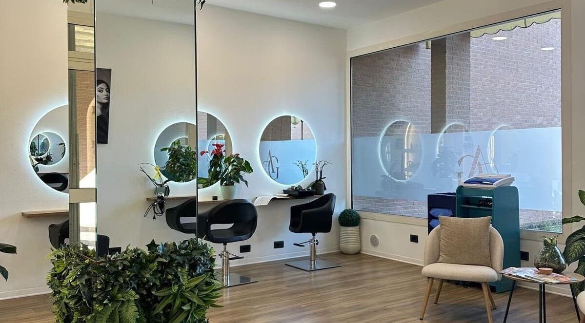 Interno moderno di Twins Hair Salon AG a Savignano Sul Panaro, modena, IT con specchi luminosi e piante.