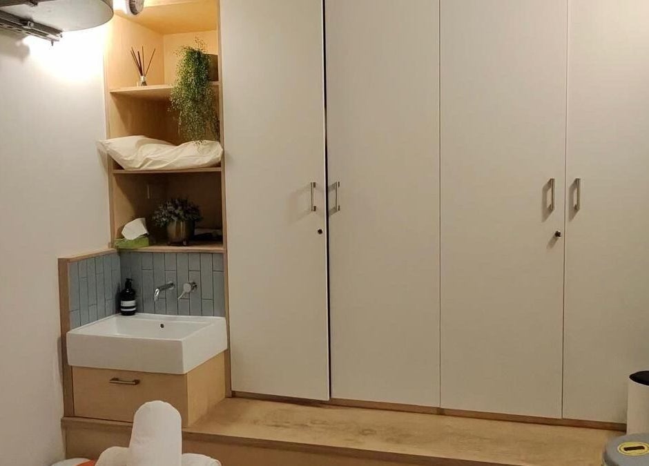 Cozy JM Massage Therapy room with sink and greenery in London, England, GB, offering relaxation and care.