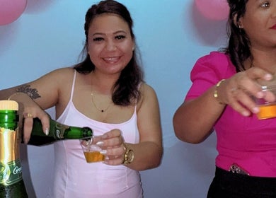 Smiling women pour drinks at S.S. Beauty Loft, Paramaribo, Paramaribo, SR, celebrating in style.