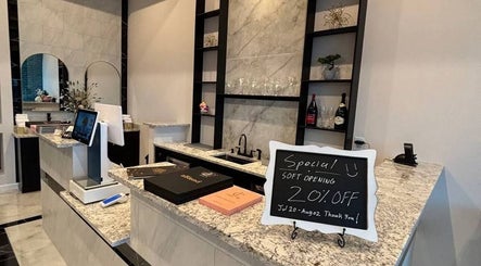 Elegant reception area at Q @ E-Luxe Nail Spa, League City, Texas, US showcasing modern design and soft opening sign.