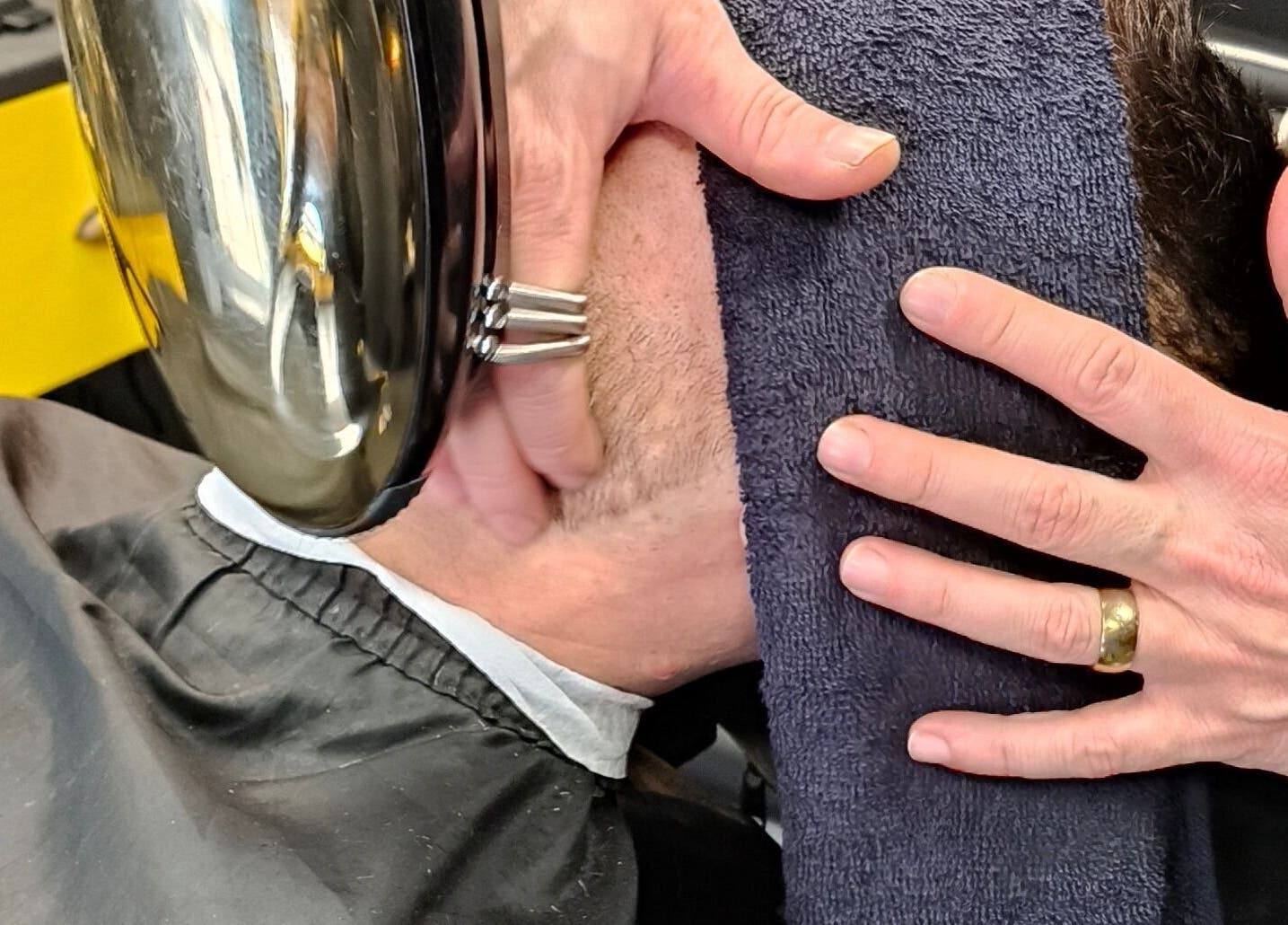 Barbeiro secando rosto de cliente na Sr. Zuca Barbearia em Amora, Setúbal, PT.