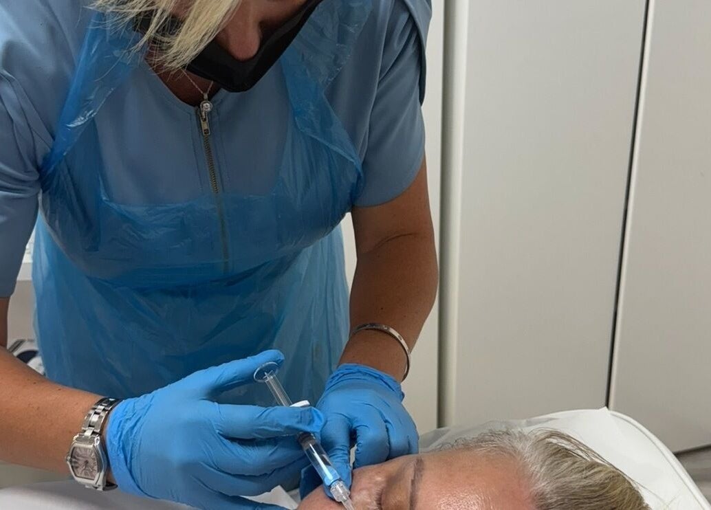 Beauty treatment in progress at Chobham Aesthetics, Chobham, England, GB. Aesthetician performing a procedure.