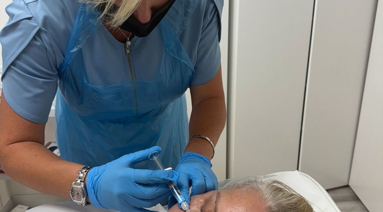 Beauty treatment in progress at Chobham Aesthetics, Chobham, England, GB. Aesthetician performing a procedure.