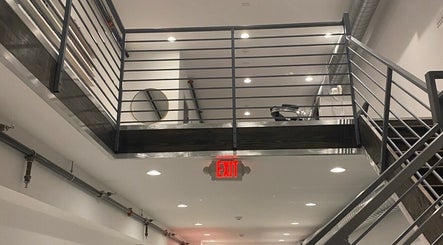 Interior loft view with sleek railing at Brand Nail Studio, Philadelphia, Pennsylvania, US.