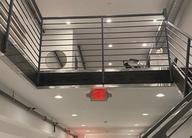 Modern interior of Brand Nail Studio in Philadelphia, Pennsylvania, US showcasing sleek mezzanine and exit sign.