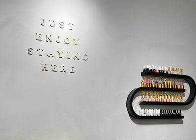 Elegant wall art featuring 'Just Enjoy Staying Here' at Beauté De Mart, Glendale, California, US.