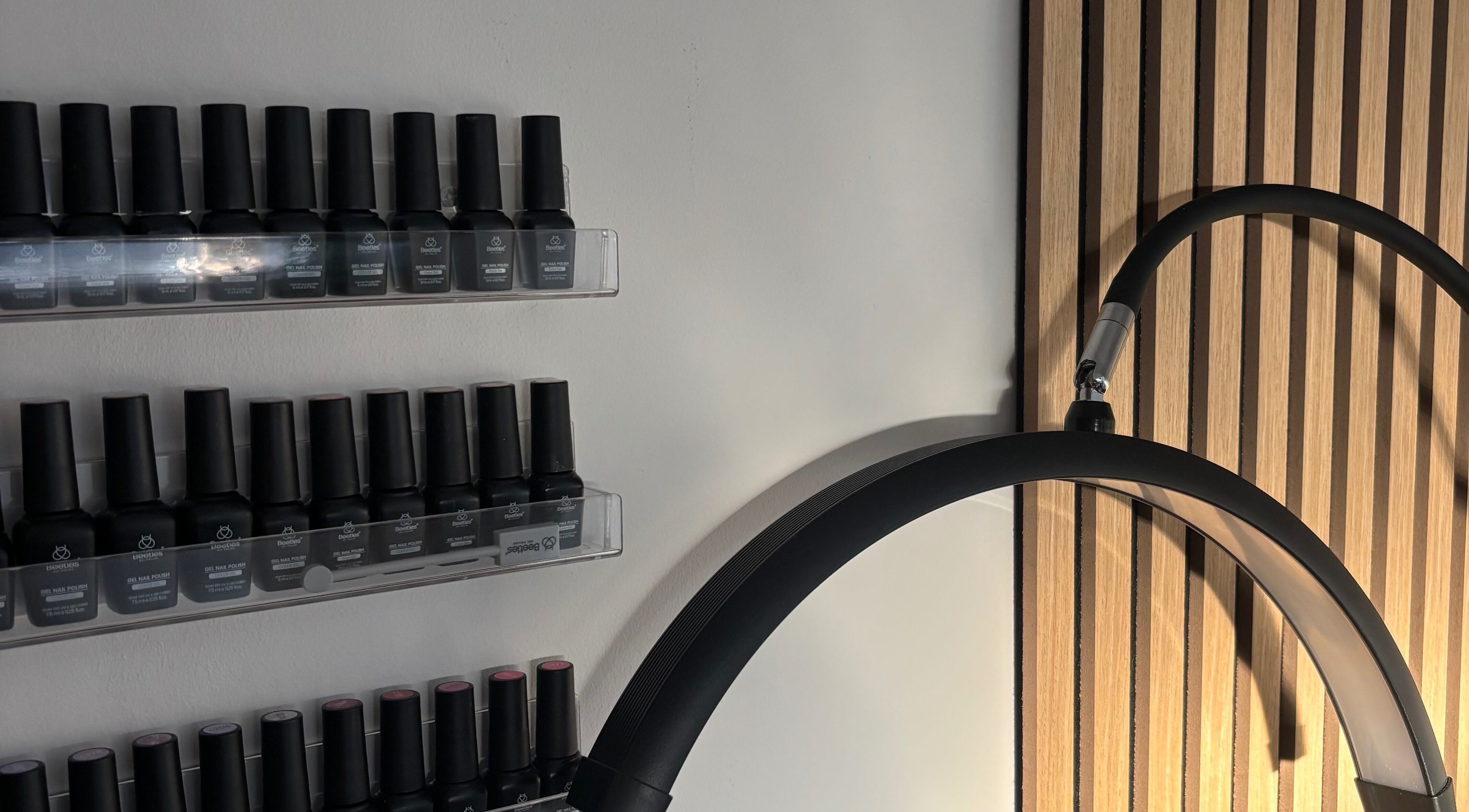 Nail polish display at Elegancewithellie, Walton, England, GB, featuring sleek shelves and modern design.
