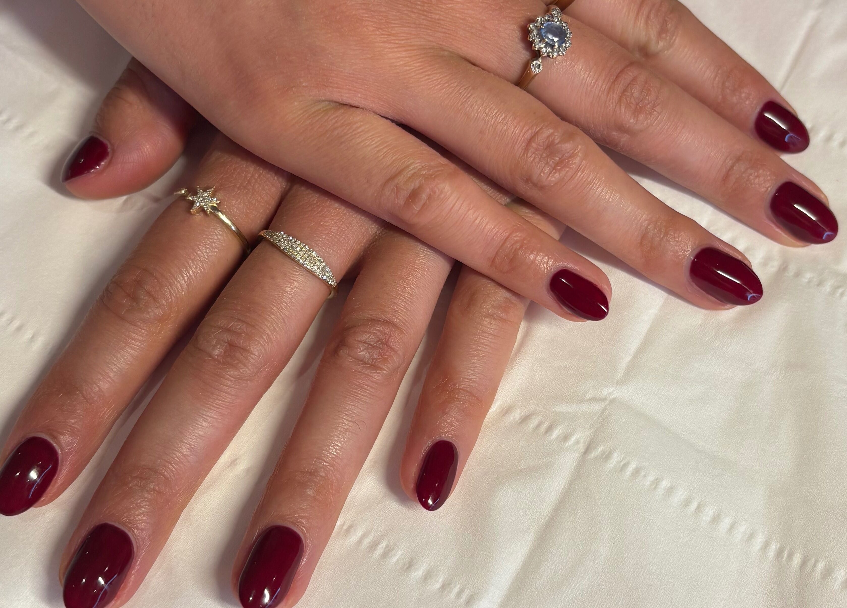 Burgundy nail design at Milita's Nails at Samantha James, Redhill, England, GB, with elegant rings.