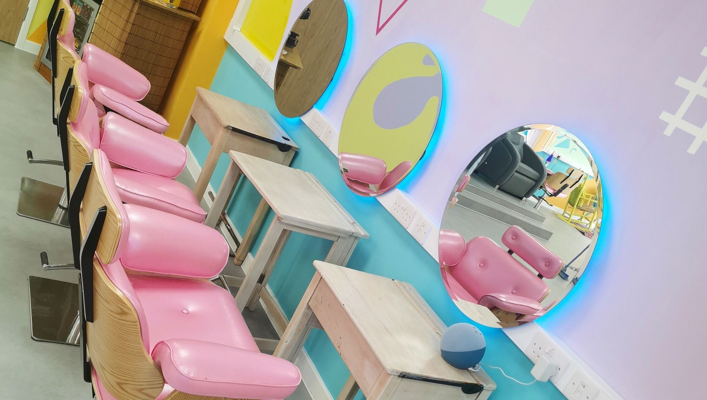 Bright salon chairs and mirrors at The Space, Southampton, England, GB, showcasing vibrant design and style.