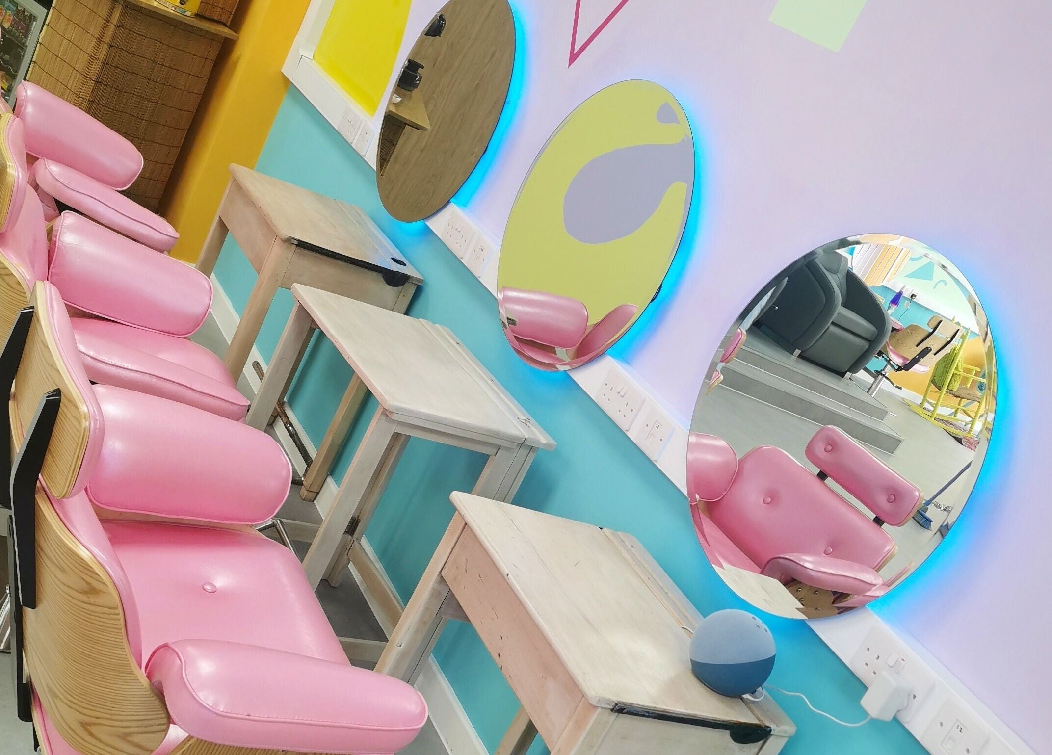 Bright salon chairs and mirrors at The Space, Southampton, England, GB, showcasing vibrant design and style.