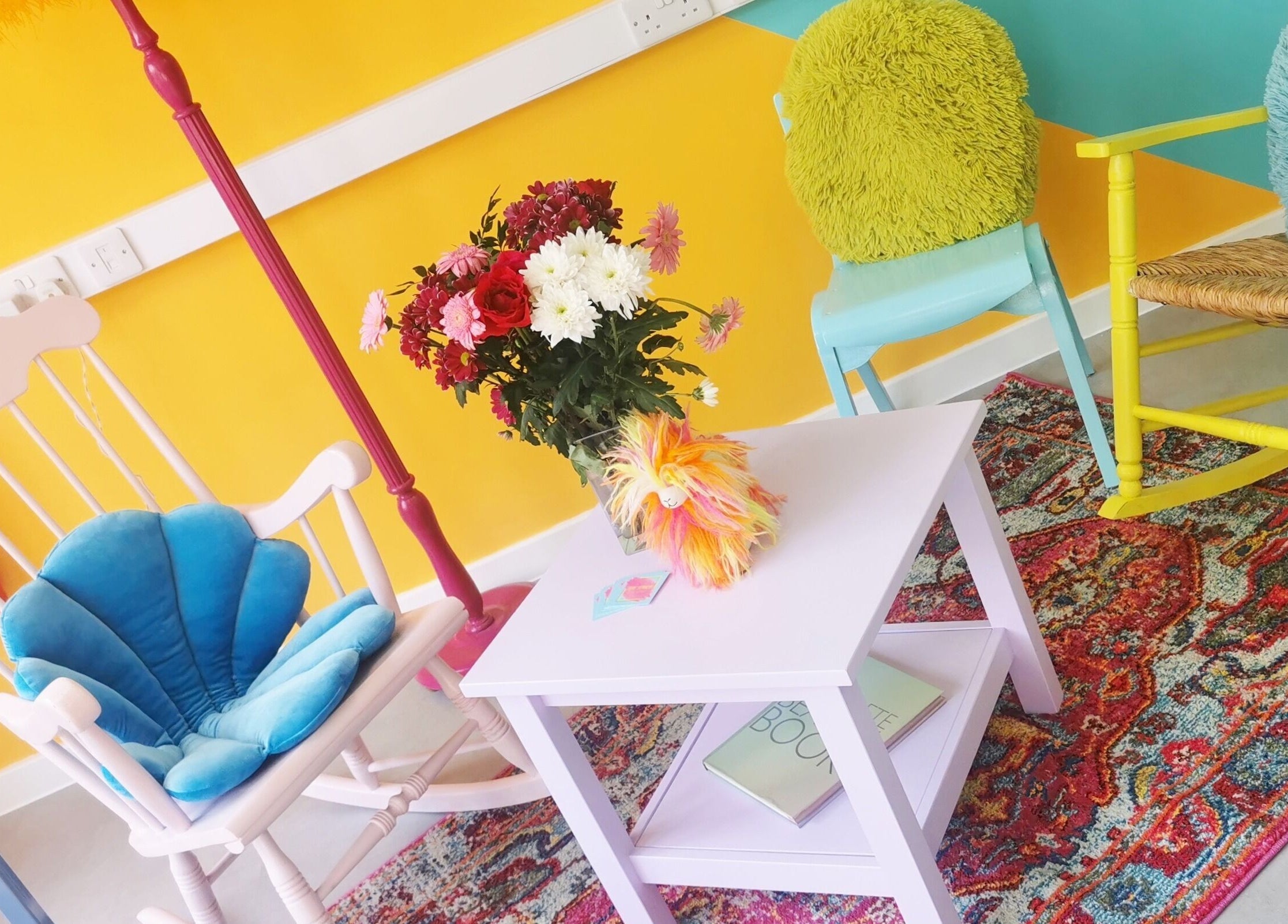 Colorful seating area at The Space, Southampton, England, GB with bright chairs and a floral centerpiece.