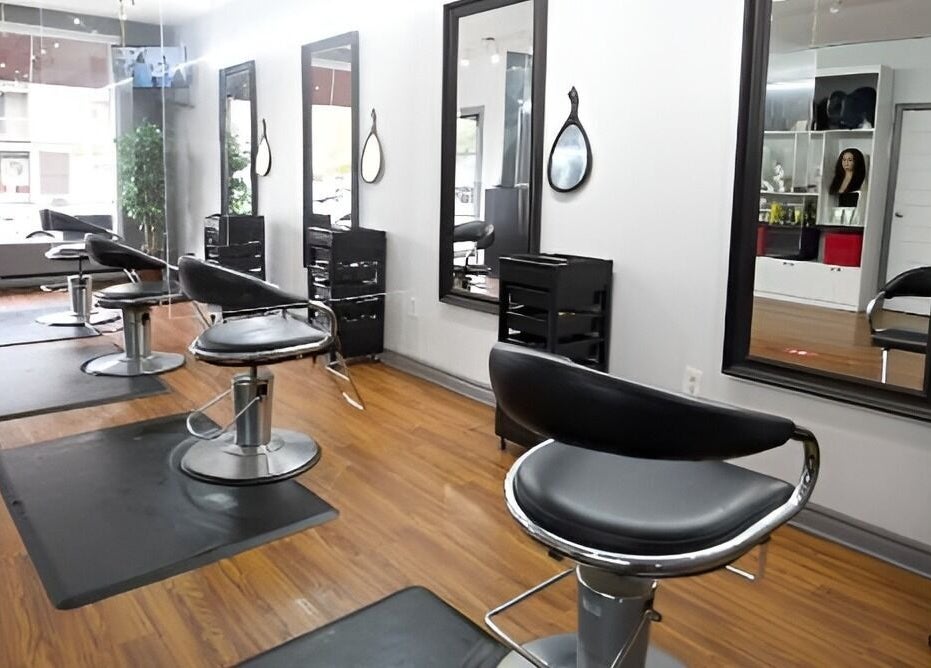 Intérieur moderne du salon Tendance Versa Inc. à Montréal, Québec, CA avec miroirs et fauteuils élégants.