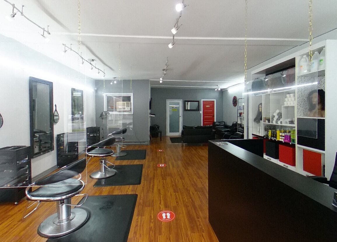 Intérieur élégant du salon Tendance Versa Inc. à Montréal, Québec, CA, avec des miroirs et sièges.