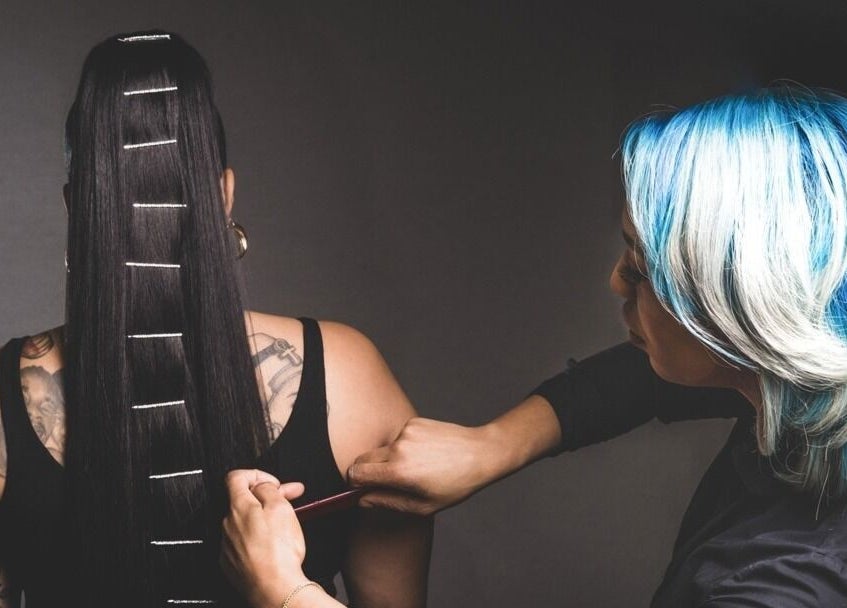 Coiffure raffinée chez Tendance Versa Inc., Montréal, Québec, CA. Styliste appliquant des épingles sur cheveux longs.