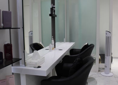Chic styling station at Hair Signature Beauty Lounge, Dubai, AE, with sleek chairs and beauty products.