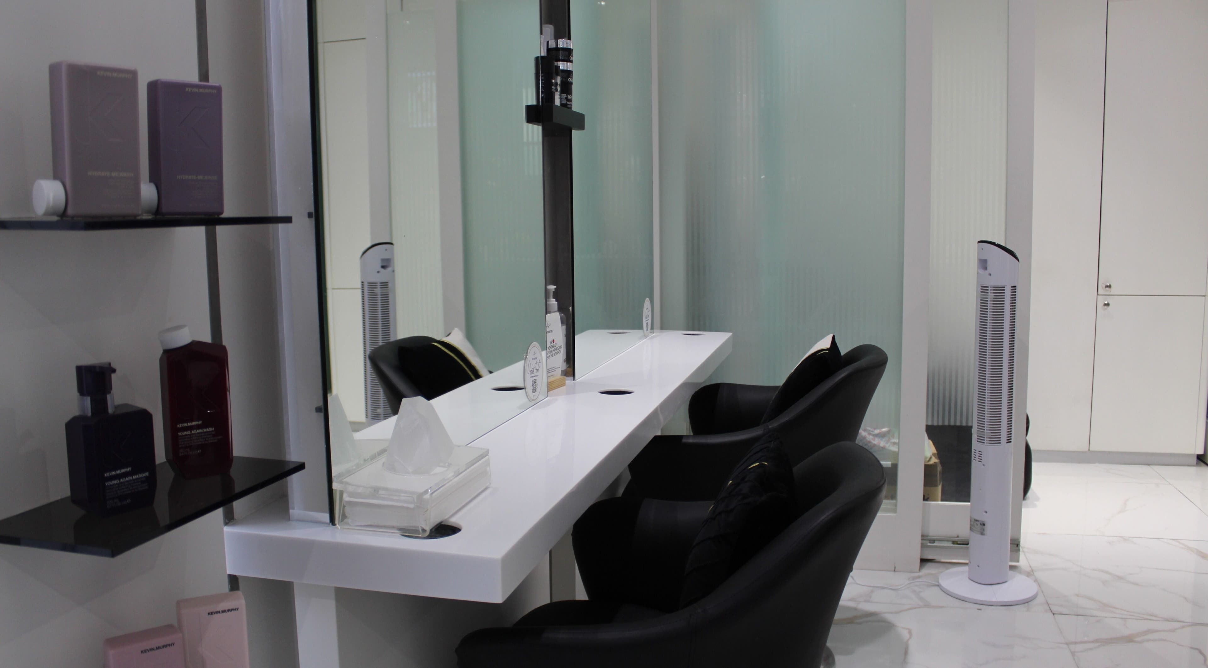 Chic styling station at Hair Signature Beauty Lounge, Dubai, AE, with sleek chairs and beauty products.