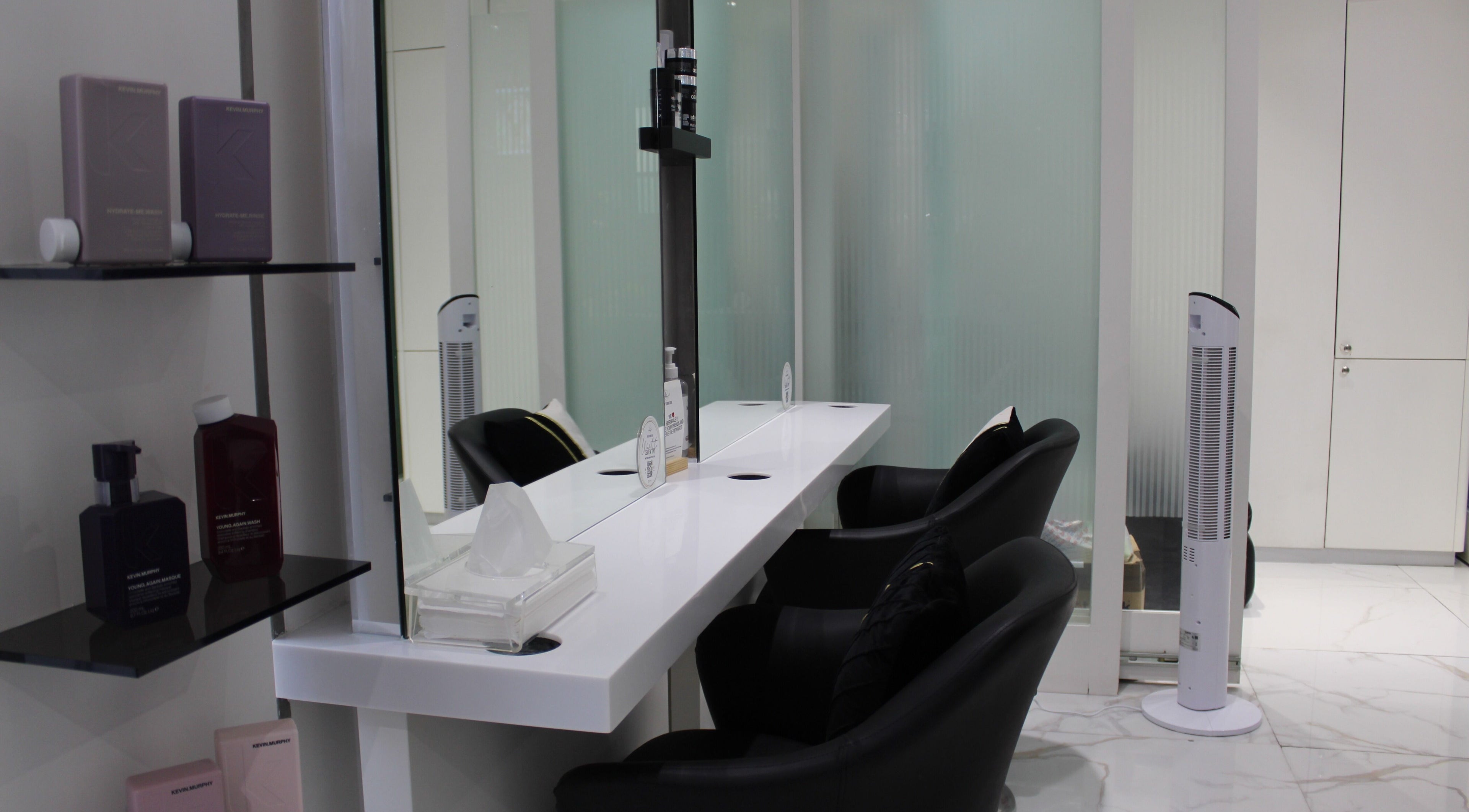 Chic styling station at Hair Signature Beauty Lounge, Dubai, AE, with sleek chairs and beauty products.