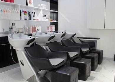 Modern wash station at Hair Signature Beauty Lounge in Dubai, AE with sleek black chairs and luxury products.