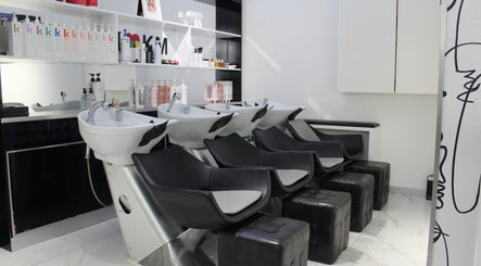 Modern wash station at Hair Signature Beauty Lounge in Dubai, AE with sleek black chairs and luxury products.