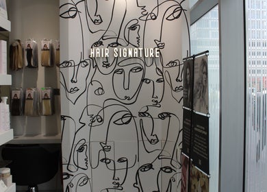Artistic wall decor inside Hair Signature Beauty Lounge, showcasing hair products, located in Dubai, AE.