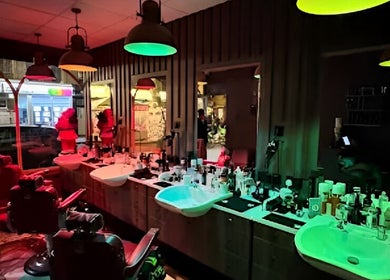 Warmly lit interior of 2 Chairs Grooming Room in London, England, GB, highlighting sinks and grooming tools.