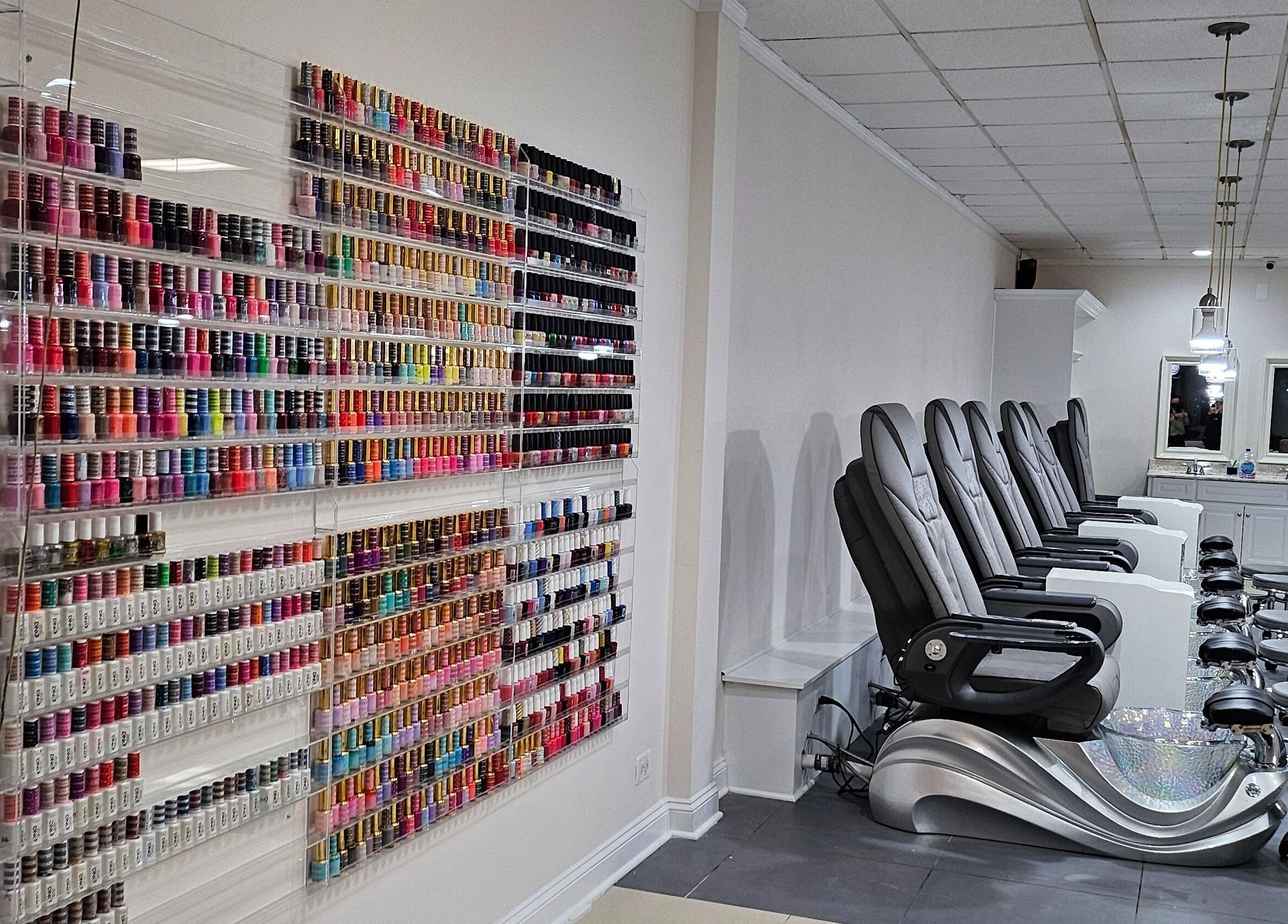 Colorful nail polish wall and comfy pedicure chairs at DIF Nails in Schaumburg, Illinois, US.