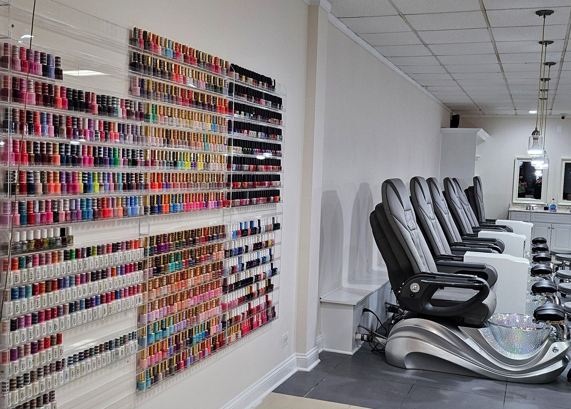 Colorful nail polish wall and comfy pedicure chairs at DIF Nails in Schaumburg, Illinois, US.