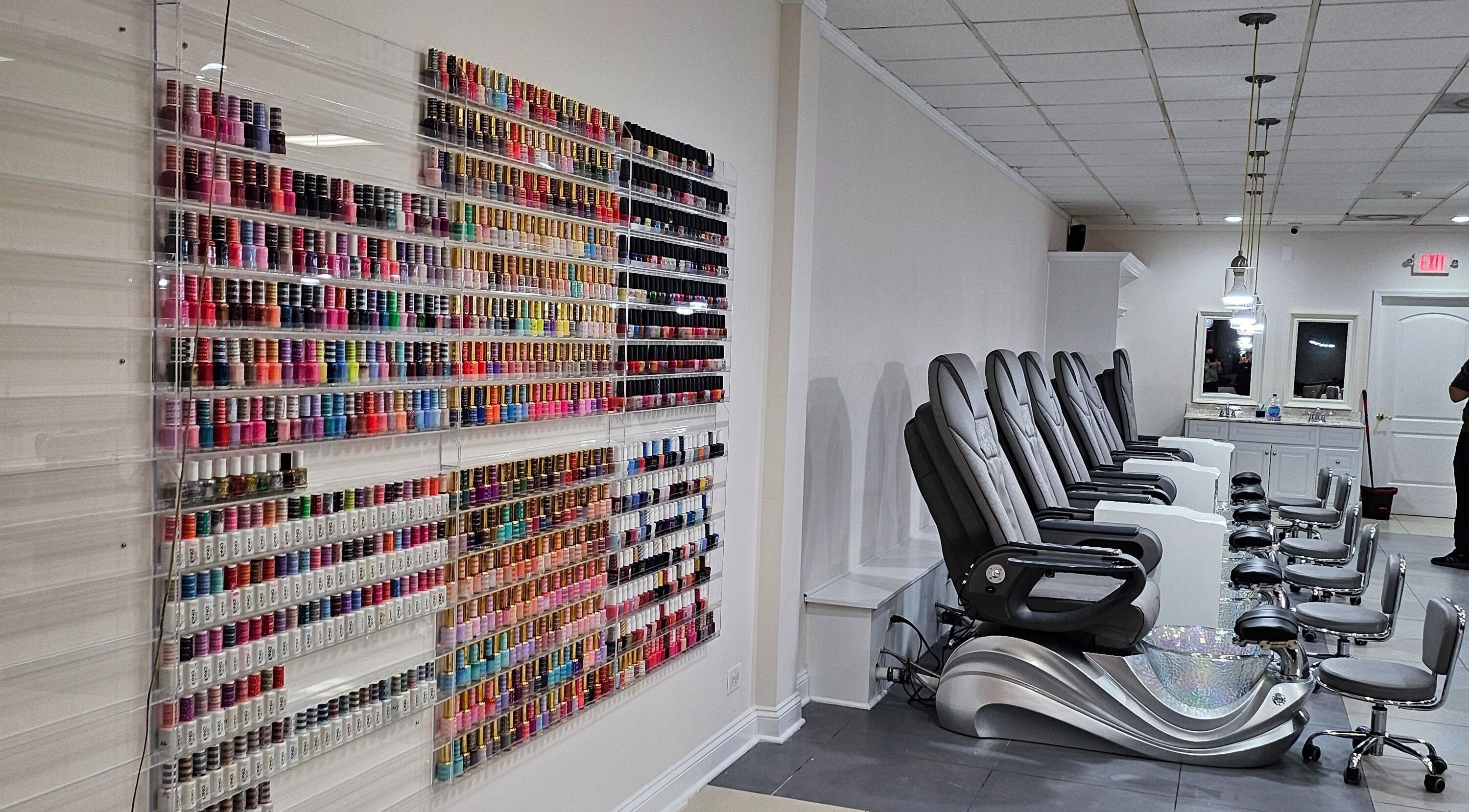 Colorful nail polish wall and comfy pedicure chairs at DIF Nails in Schaumburg, Illinois, US.
