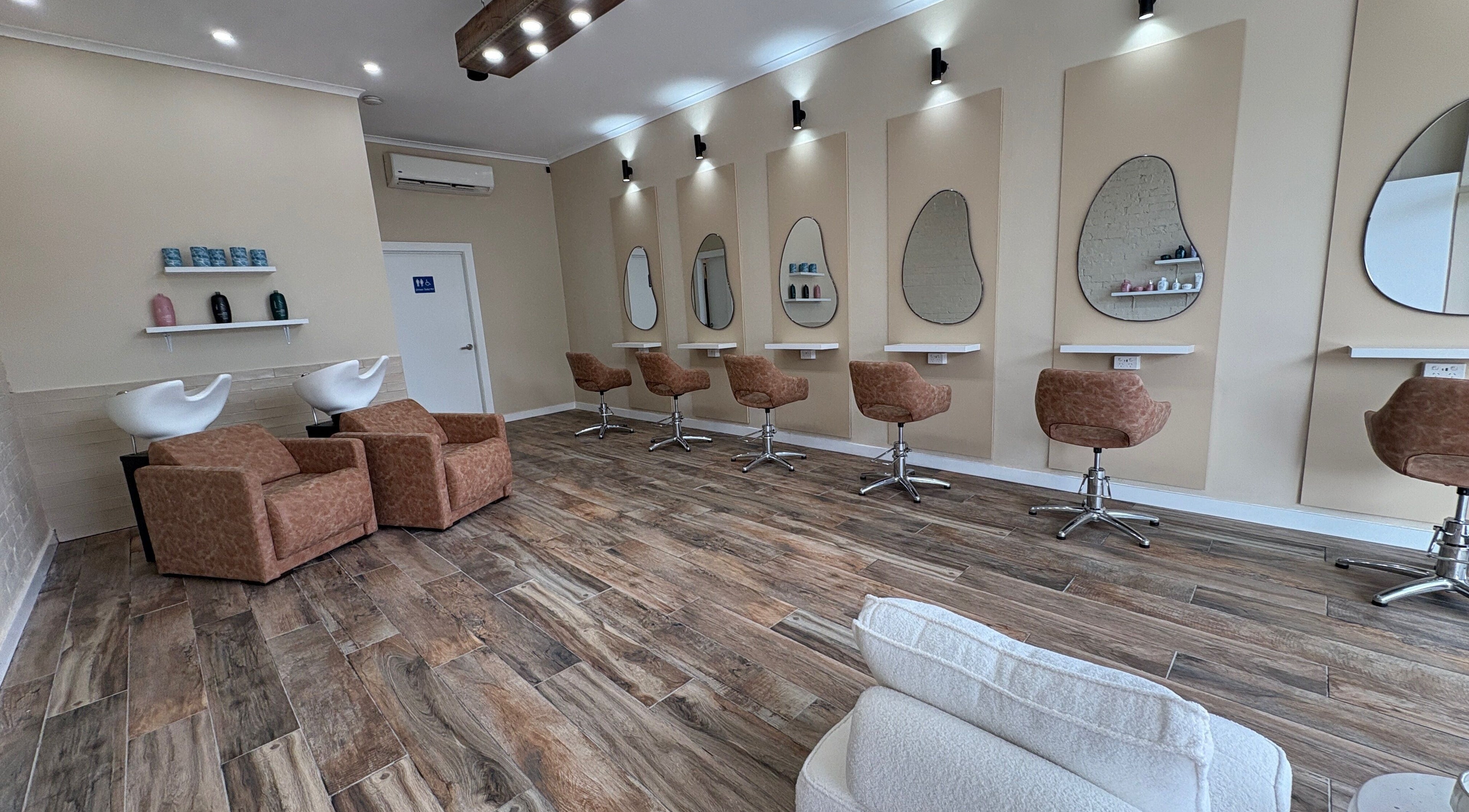 Modern interior of Blissfully Blonde salon in Randwick, New South Wales, AU showcasing stylish chairs and mirrors.
