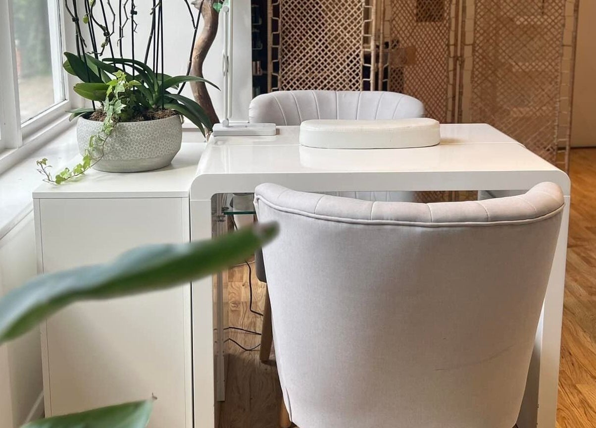 Elegant manicure station at Oval & Arch at Nuve Clinic, Cranbrook, England, GB, featuring plush chairs and plants.