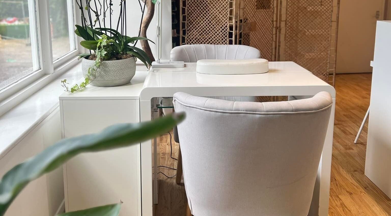 Elegant manicure station at Oval & Arch at Nuve Clinic, Cranbrook, England, GB, featuring plush chairs and plants.