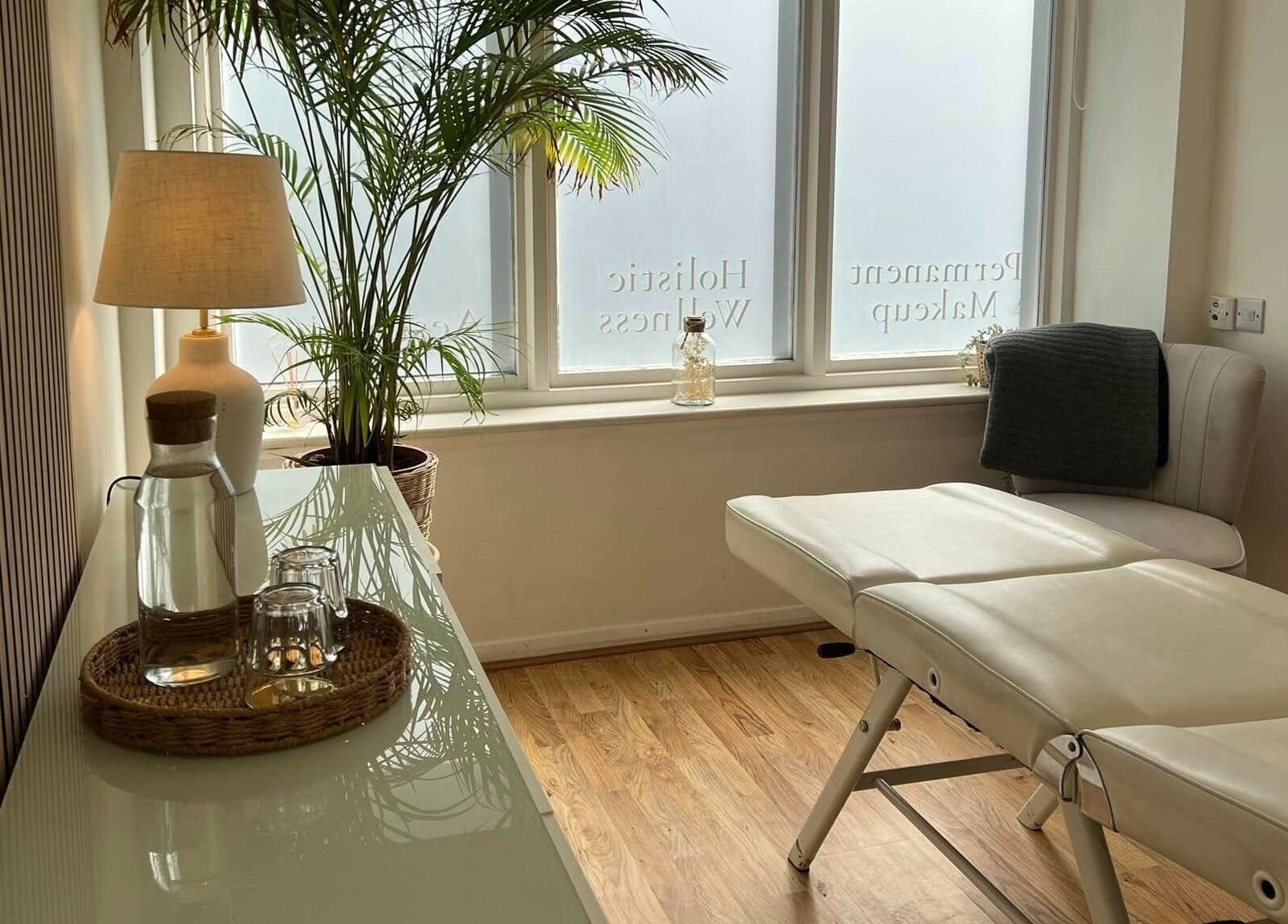 Relaxing treatment room at Oval & Arch at Nuve Clinic, Cranbrook, England, GB, with massage bed and greenery.