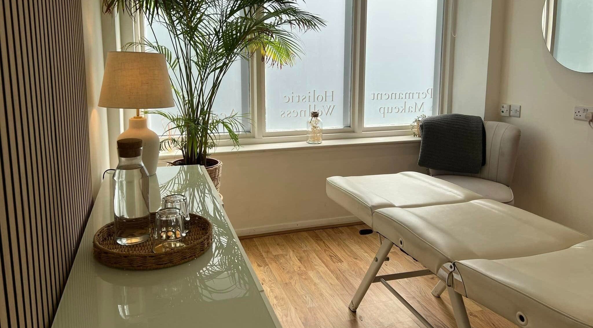 Relaxing treatment room at Oval & Arch at Nuve Clinic, Cranbrook, England, GB, with massage bed and greenery.