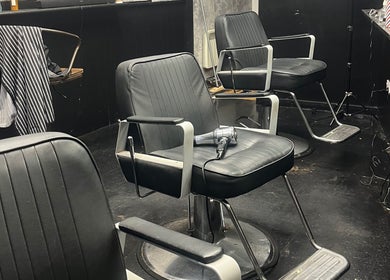 Modern black salon chairs at RUDEBOYS, Portlaoise, County Laois, IE, showcasing a stylish barber setup.